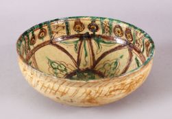 A GOOD IRAN STYLE POTTERY BOWL, decorated with green & biscuit grounds, with floral motif