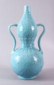 A CHINESE PALE BLUE GLAZED PORCELAIN DOUBLE GOURD VASE, the body carved with lotus decoration and