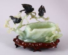 A CHINESE CARVED JADE BIRD FORMED ASHTRAY, carved as a tree stump with pine growth and birds