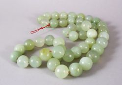 A SET OF CHINESE CARVED CELADON JADE BEAD NECKLACE, comprising 49 carved beads of varying size.