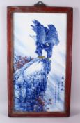 A CHINESE BLUE, WHITE & COPPER RED PORCELAIN PANEL OF A HAWK- depicted upon a rocky outcrop, the
