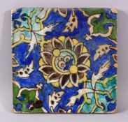 A SMALL SQUARE FORMED QAJAR POTTERY TILE SECTION, with underglaze blue and floral motif decorations,