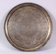 A 19TH CENTURY INDIAN WHITE METAL CHASED FLORAL DISH, decorated with native floral scenes 34cm