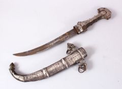 A GOOD EASTERN WHITE METAL JAMBIYA DAGGER, with onlaid white metal decoration, with han dles and