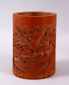 A CHINESE CARVED BAMBOO BRUSH POT, carved in canton style with figures in landscapes and temples,