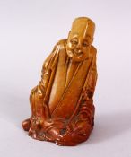 A CHINESE CARVED SOAPSTONE FIGURE OF A JOLLY MAN, in seated position, 11cm