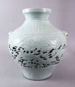 A CHINESE MING STYLE CELADON CARVED OPENWORK JAR, the body carved with dragons and lotus, with