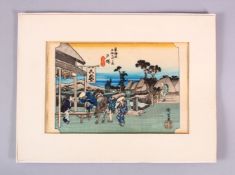A JAPANESE WOODBLOCK PRINT - FIGURES AND HORSE - the figures stood in a windswept landscape with a