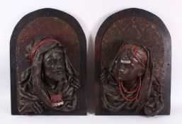 A PAIR OF EGYPTIAN BRONZE RELIEF FIGURAL BUSTS, depicting a prince & princess,each mounted to a