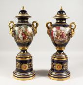 A SUPERB PAIR OF VIENNA VASES, COVERS AND STANDS, the rich blue ground edged in gilt and painted