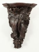 A BLACK FOREST CARVED WOOD WALL BRACKET, game, grapes and leaves. 23ins high
