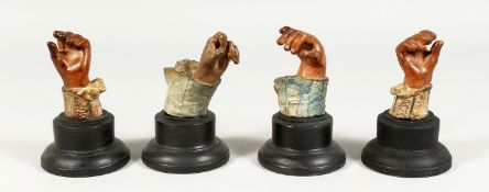 FOUR CARVED TERRACOTTA STUDIES OF HANDS in various poses. 4.5ins high.