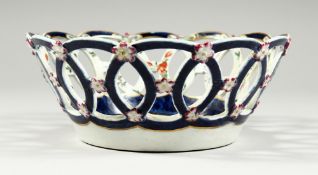 A WORCESTER BASKET, painted with flowers on a blue scale ground, some professional repair.