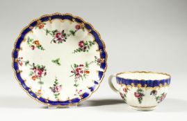 A WORCESTER FLUTED TEACUP AND SAUCER painted with chains of flowers under a blue border.