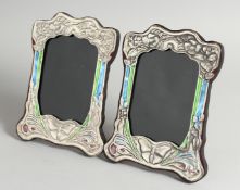 A PAIR OF ART NOUVEAU STYLE SILVER AND ENAMEL PHOTOGRAPH FRAMES with butterflies 3ins x 4.5ins