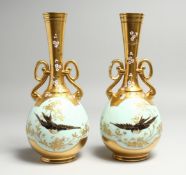 A GOOD PAIR OF M. REDON, LIMOGES TWO HANDLED GILT VASES, duck-egg-blue ground painted with