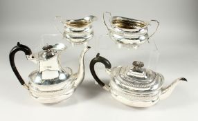 A VICTORIAN SILVER FOUR PIECE TEA SET with gadrooned edge, comprising tea pot, hot water jug , sugar