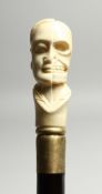 A BONE WALKING STICK 'HALF FACE, HALF SKULL' 35ins high