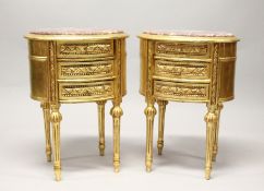 A PAIR OF FRENCH STYLE GILT WOOD OVAL THREE DRAWER BEDSIDE CHESTS, with marble tops. 2ft 3ins high x