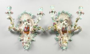 A GOOD PAIR OF MEISSEN PORCELAIN TWO LIGHT WALL SCONCES with cupid and encrusted with flowers and