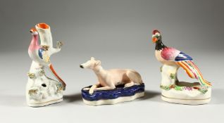 TWO STAFFORDSHIRE FLOWER ENCRUSTED BIRD PEN HOLDERS 5.5 & 6 ins high and a greyhound 5ins long (3).