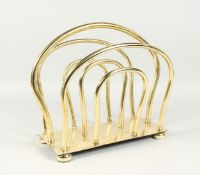 AN EDWARDIAN BRASS TWO DIVISION MAGAZINE RACK on ball feet. 13ins long.