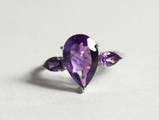 A SILVER THREE STONE AMETHYST RING