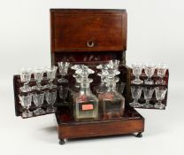 A 19th CENTURY ROSEWOOD DRINKS BOX with brass lines opening to reveal four decanters and stoppers