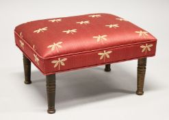 A SMALL FOOTSTOOL UPHOLSTERED with a dragonfly material 1ft 6ins long x 11ins high.