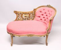 A VICTORIAN MAHOGANY PIERCED AND GILDED CHAISE LOUNGE, with button back and padded seat on