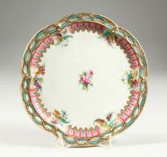 AN ENGLISH PORCELAIN PLATE with pierced border and painted with roses. 9ins diameter.