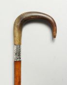 A VICTORIAN WALKING STICK with rhino crook handle and .800 silver band. 32ins long.