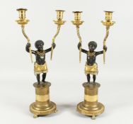A SUPERB PAIR OF EMPIRE BRONZE AND GILT BRONZE TWO BRANCH CANDLESTICKS of nubian children holding