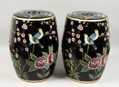 A PAIR OF CHINESE FAMILLE NOIR GARDEN SEATS decorated with birds and roses 18ins high.