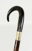 A LARGE VICTORIAN WALKING STICK with crook handle, possibly rhino, and gilt band. 42ins long.