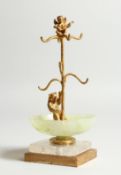A JADE , CRYSTAL AND GILDED BEAR RING STAND on a square base 6.5ins high.