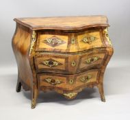 A GOOD SERPENTINE FRONTED BOMBE COMMODE, with cross banded top three long drawers with ormolu mounts