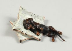 A COLD CAST PAINTED BRONZE DASHOUNDS ON TWO CUSHIONS 3ins long.