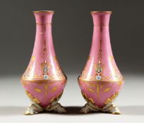 A SMALL PAIR OF SEVRES PINK GROUND VASES with gilt and pierced work. Mark in blue A.M. 6ins high