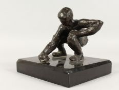 JUGANDO CANICAS (MEXICAN) A BRONZE CROUCHING MAN. Signed, on a black marble base. 5ins high.