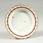 A BRISTOL SMALL PLATE decorated with two random leaves, a burnt orange around the border entwined
