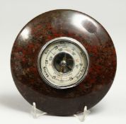 A 20TH CENTURY SERPENTINE STONE CIRCULAR ANNEROID BAROMETER. 7ins diameter.