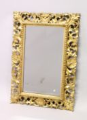 A GOOD 19TH CENTURY FLORENTINE GILT FRAMED RECTANGULAR MIRROR, the frame with well carved leaf and
