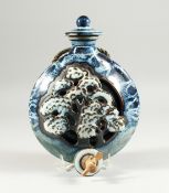 A STUDIO POTTERY WINE BOTTLE, pierced and moulded with a tree design. 10ins long