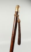 A LONG VICTORIAN TAPERING CEREMONIAL CANE with gilded handle and rope. 48ins long