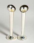 A PAIR OF SILVER FLOWER VASES on loaded circular bases. 7.5ins high, London, 1962.