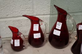 A graduated set of three Whitefriars red beak jugs.