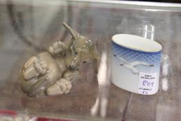 A Copenhagen puppy dog and a small vase.