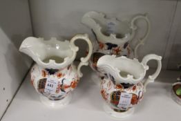 A graduated set of three Imari decorated jugs.