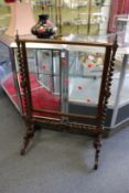 A good Victorian mahogany fire screen with clear glazed panel supported on barley twist columns.